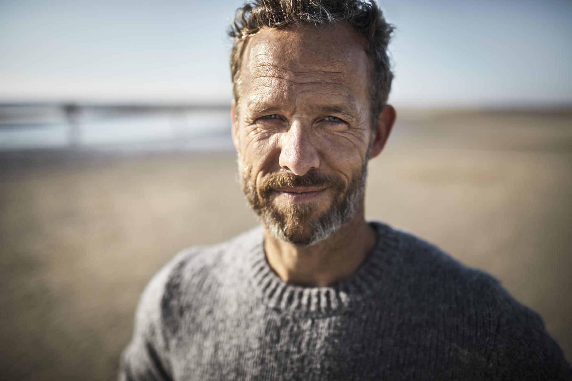 mann_am_strand_im_winterpullover