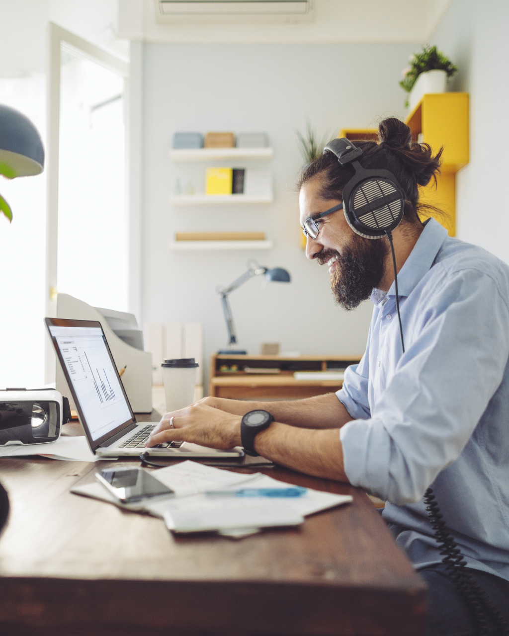 mann_arbeitet_mit_kopfhoerern_am_laptop_im_homeoffice-1